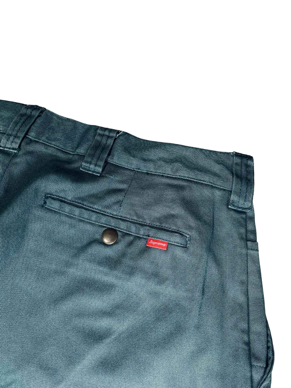 Sötétzöld Supreme streetwear nadrág hátsó zseb részlet, fém gombbal és piros címkével