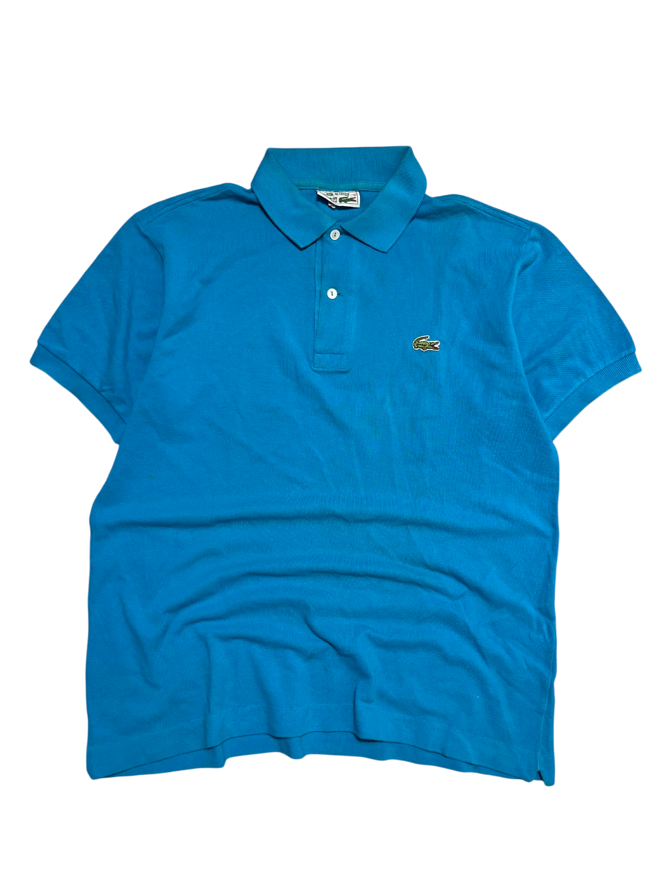 Kék rövid ujjú Lacoste vintage galléros póló krokodil logóval, streetwear stílusban.