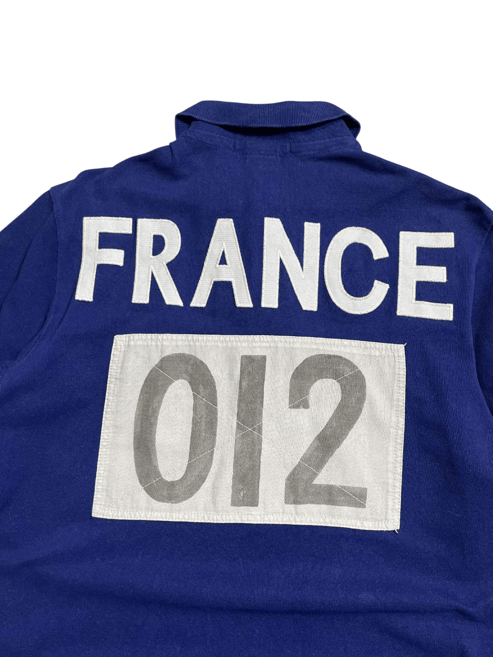 Kék vintage póló hátulján fehér FRANCE felirat és 012 szám, streetwear stílusban