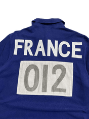 Kék vintage póló hátulján fehér FRANCE felirat és 012 szám, streetwear stílusban