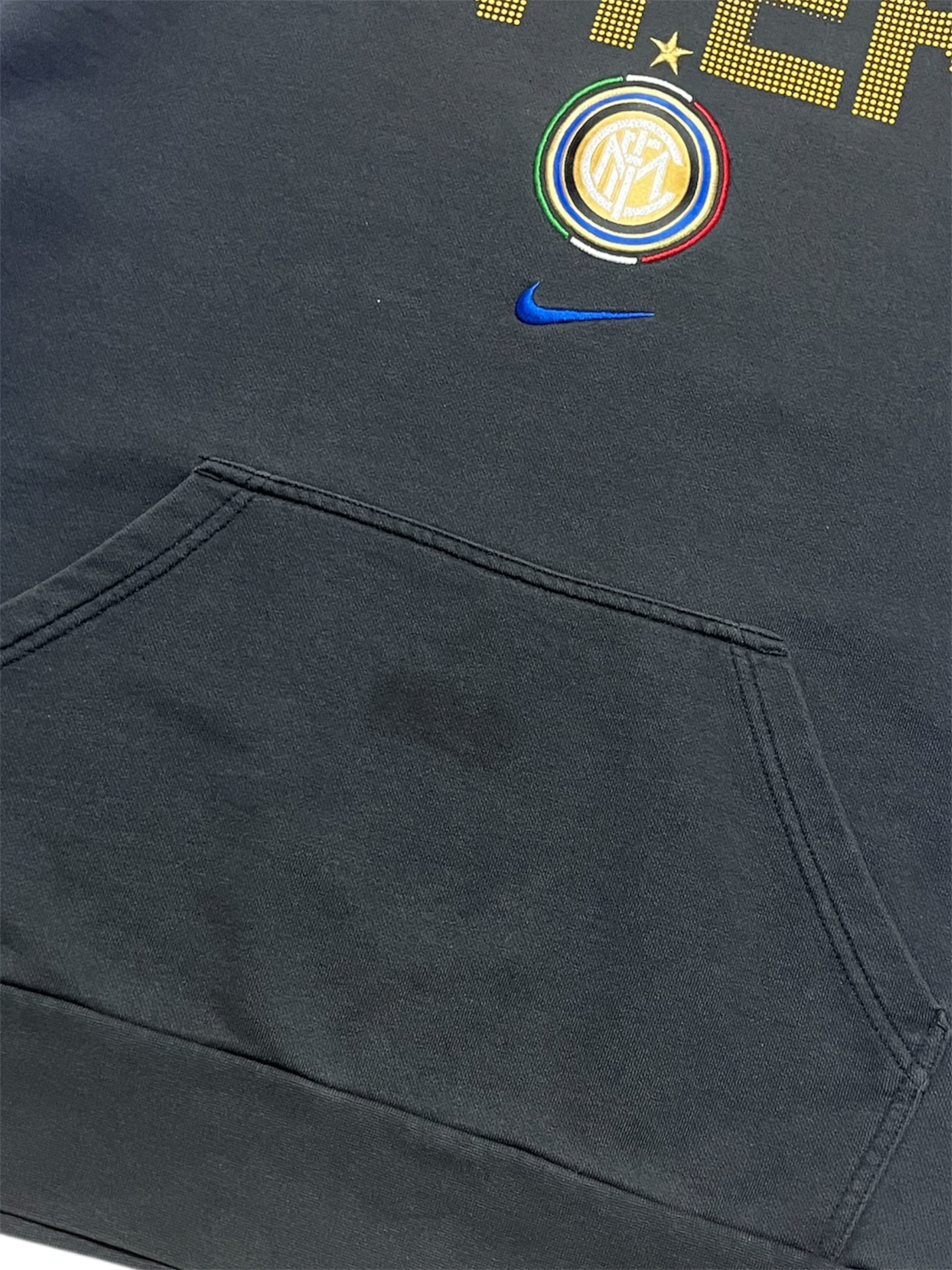 Fekete streetwear pulóver zsebbel, Inter Milan címerrel és kék Nike logóval díszítve.