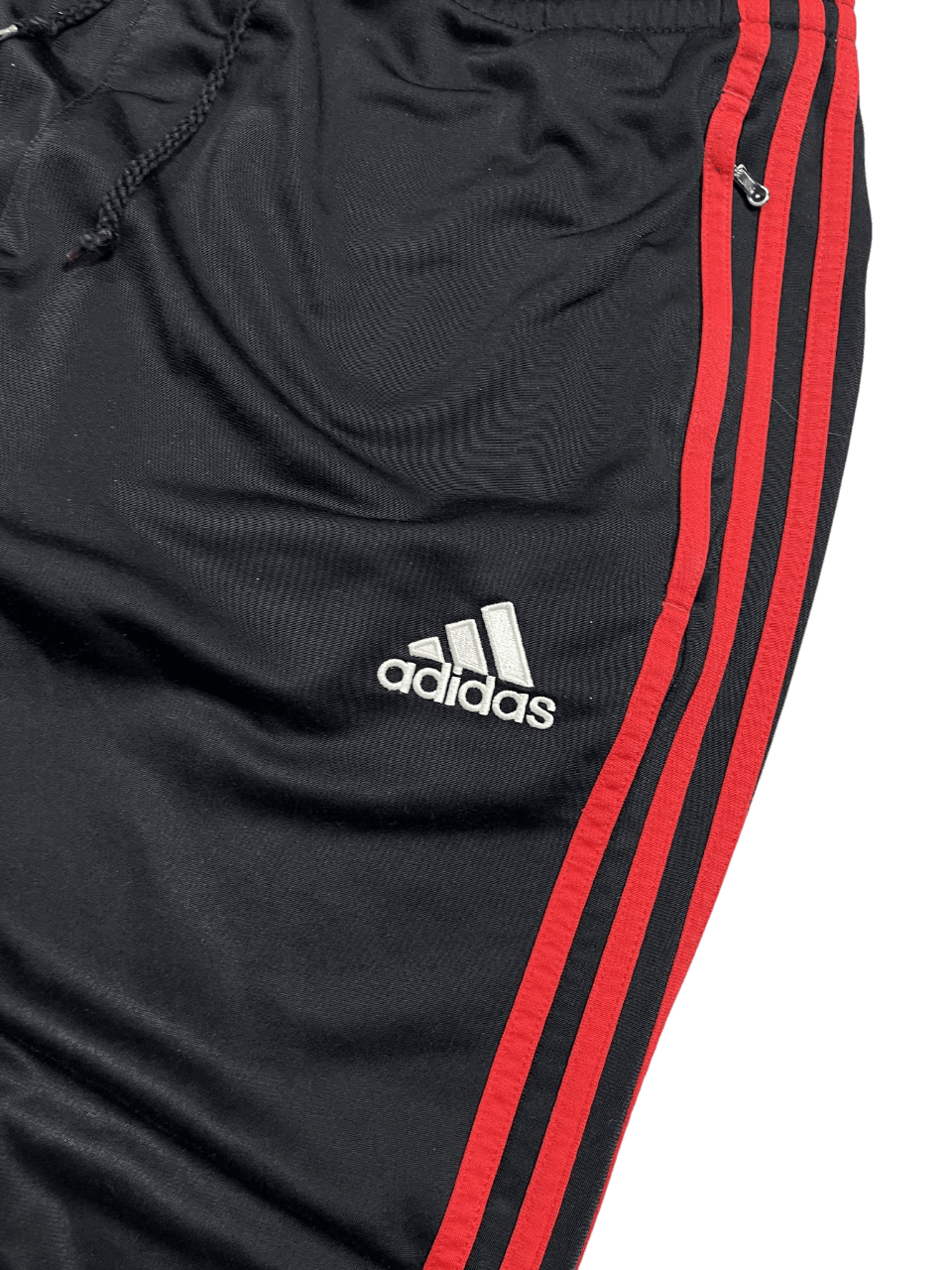 Fekete Adidas melegítőnadrág piros csíkokkal és logóval, streetwear stílus